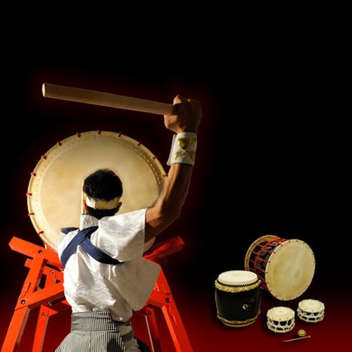 The back of someone beating a Taiko drum 