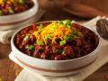 Bowls of chili with green onions and shredded cheese on top