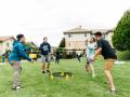 A group of 4 students playing spikeball on a lawn in residential housing 