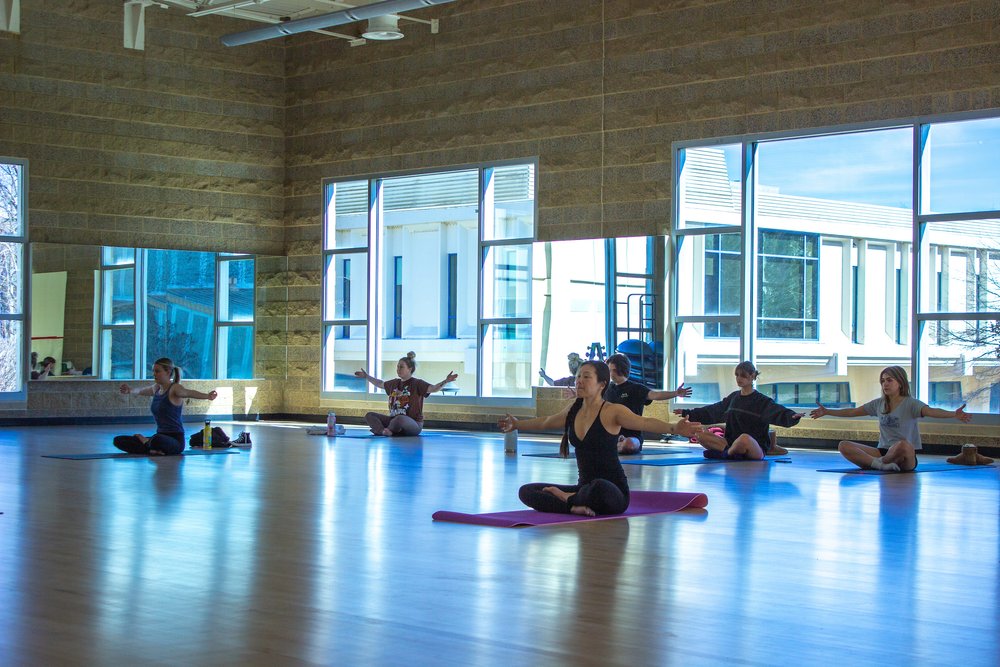 Students in the Campus Recreation Center posing on yoga mats 