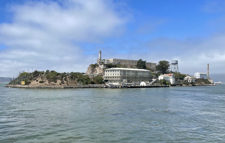 Alcatraz Island with water in the foreground and clouds in the background