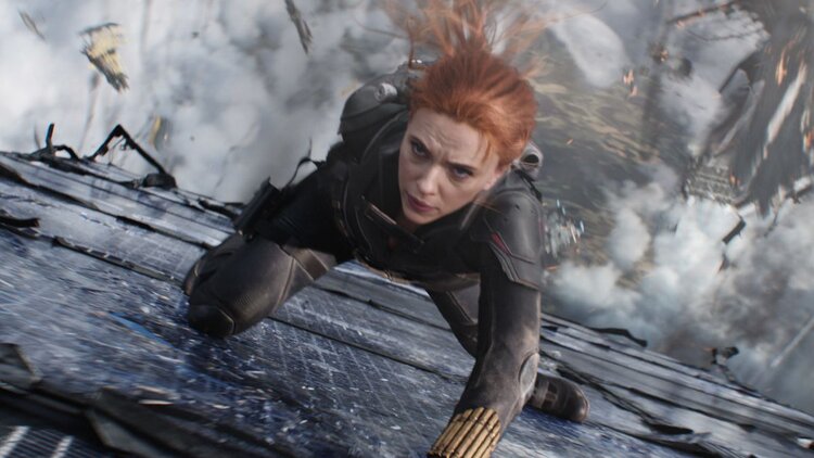 A screen capture from the film 'Black Widow' featuring the character Black Widow in the foreground with an explosion in the background