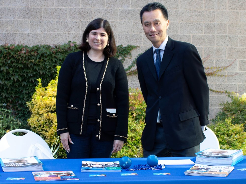 Two people smiling while tabling at an outdoor Career Fair Event