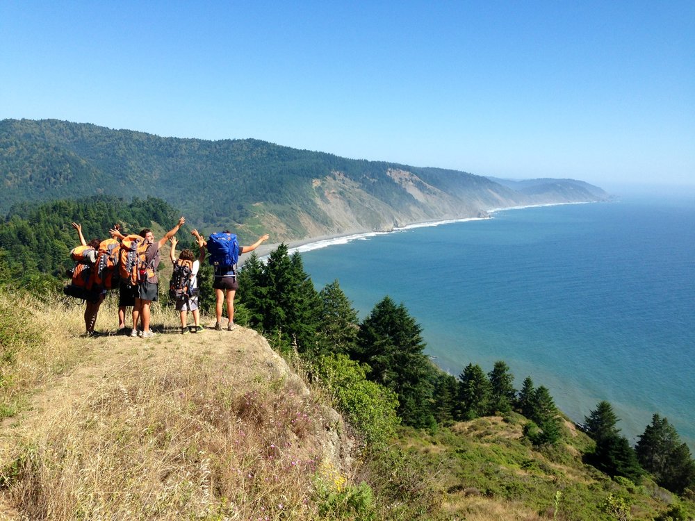 Hikers posing on a coastal cliffside