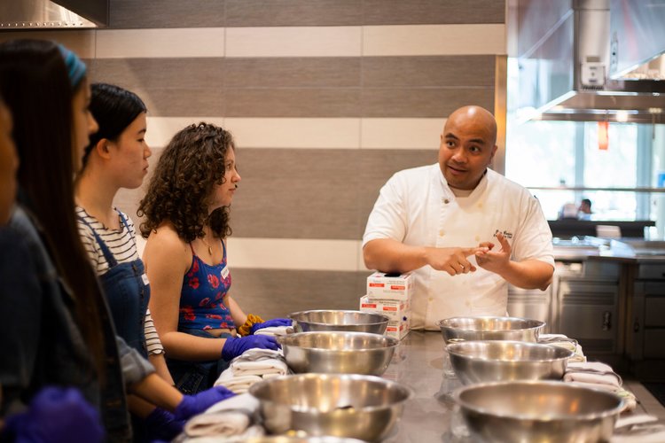 People watching a chef do a demonstration in a cooking class