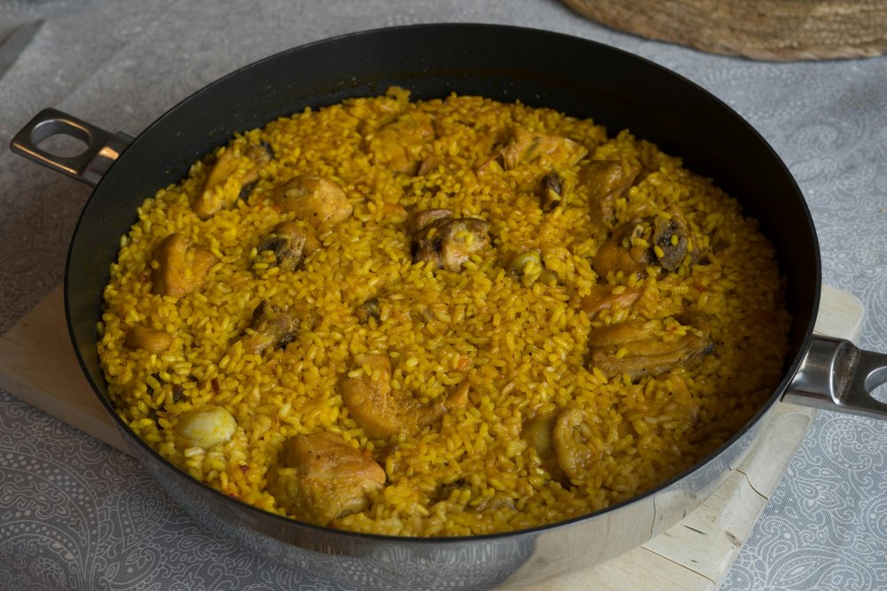 A large cooking wok filled with paella 