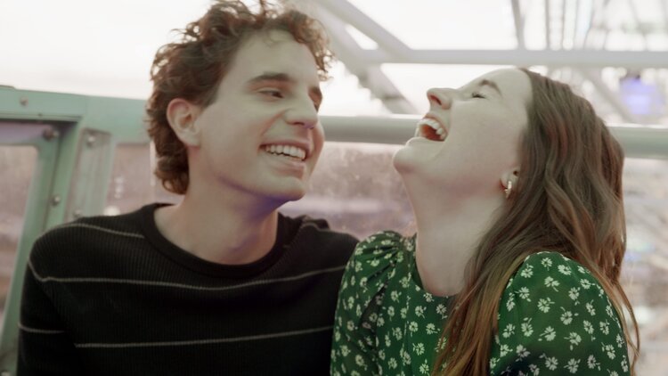 A still from the film 'Dear Evan Hansen' of two people laughing while on a ferris wheel ride