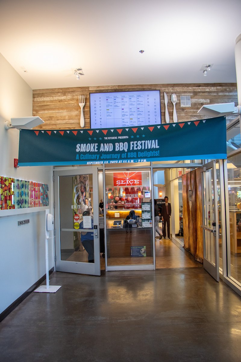 A banner for the Smoke & BBQ Festival outside of The Kitchens doorway