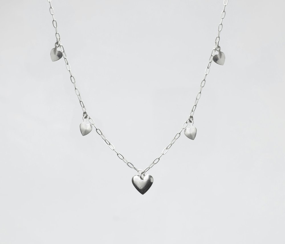 A silver necklace with heart charms