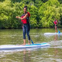 Two people smiling while paddleboarding 