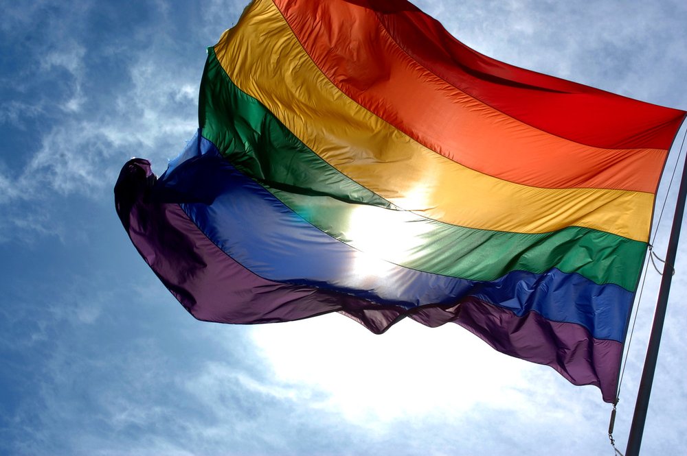 a pride flag billowing in the wind