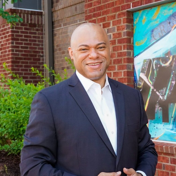 Portrait of Quentin Williams smiling and wearing a navy blue suit 