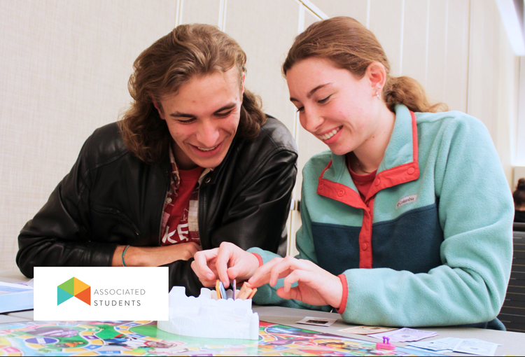 Students smiling while playing a board game