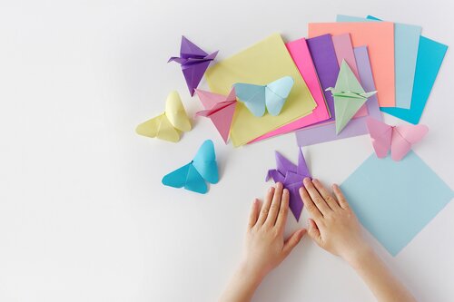 Someone folding multicolored origami butterflies 
