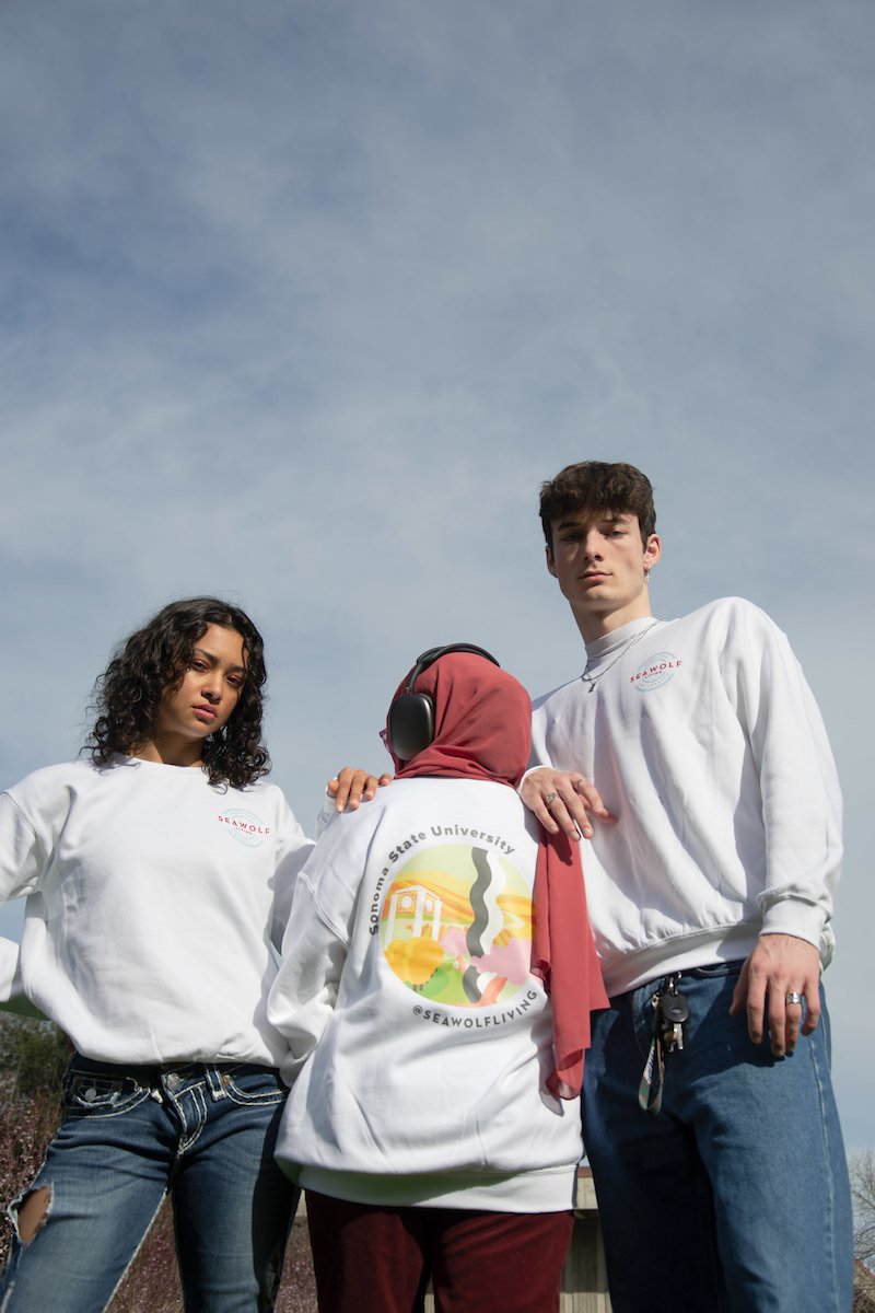 Students posing while wearing SSU Student Living merch