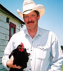 Scott Gerber wearing a cowboy hat and holding a chicken