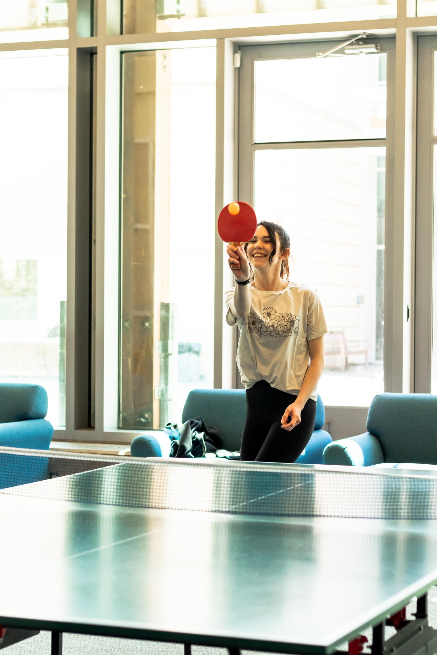 Person smiling while playing table tennis