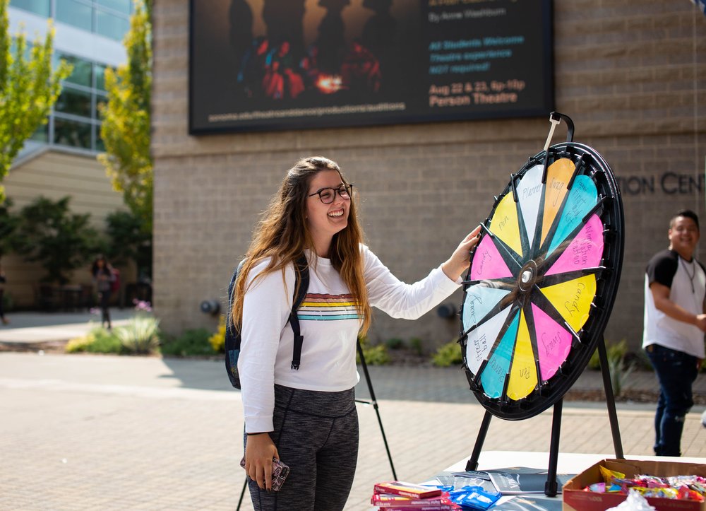 Someone playing a spinning wheel game while tabling at Seawolf Plaza