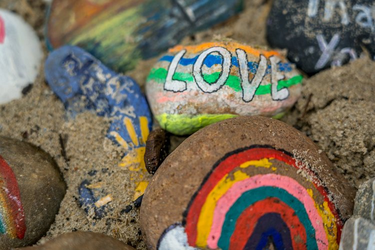 Painted rocks with rainbows and LGBTQ+ support messages on them