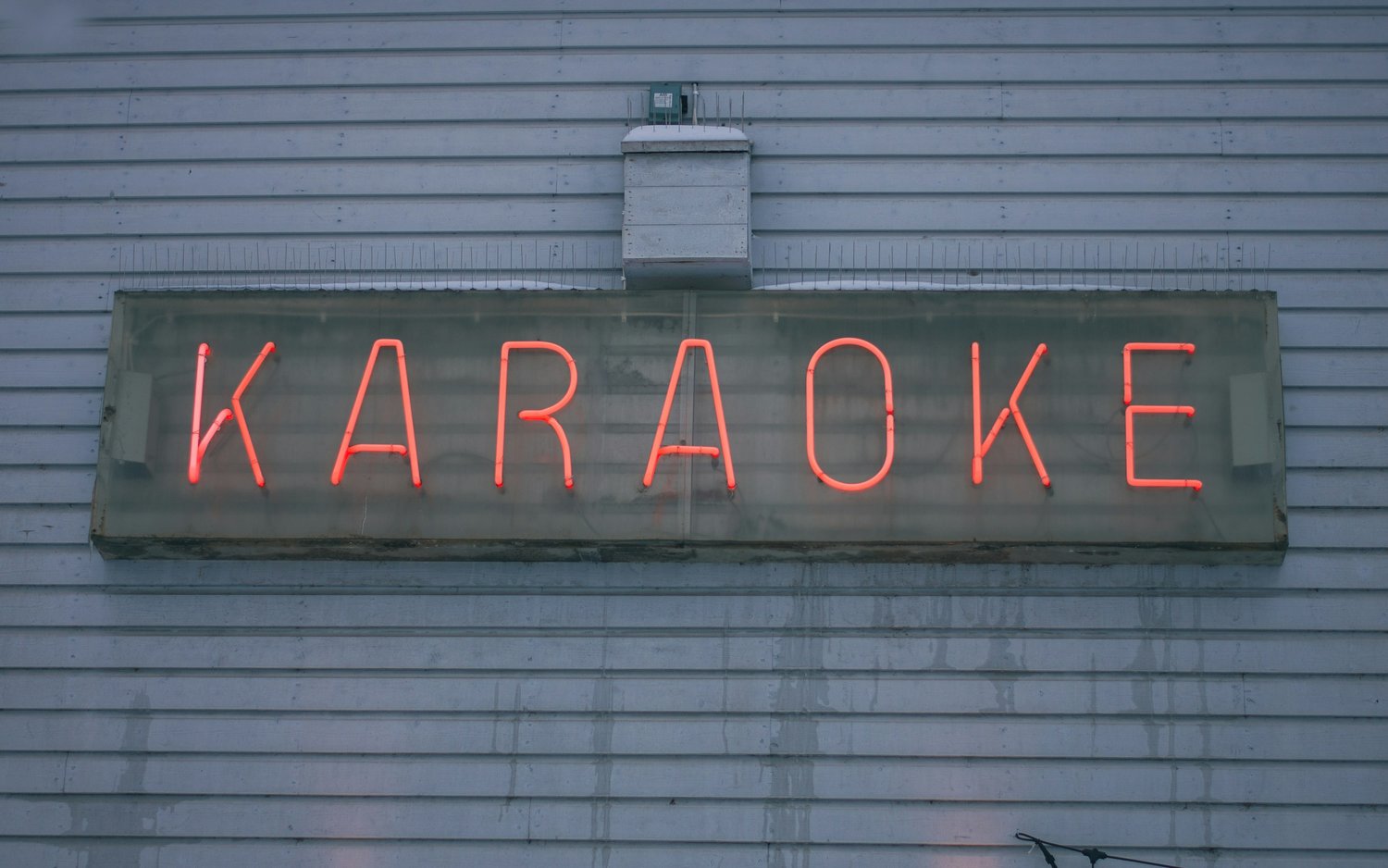 A red neon sign with the word 'Karaoke'