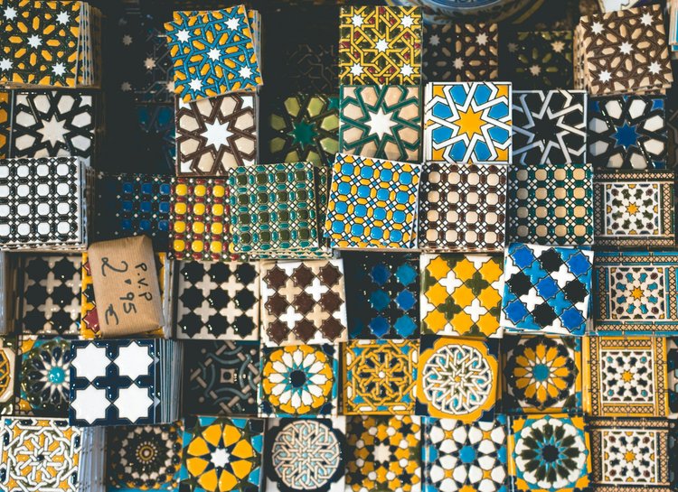 A variety of colorful patterned tile coasters