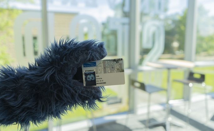 Lobo's paw holding their Student ID card