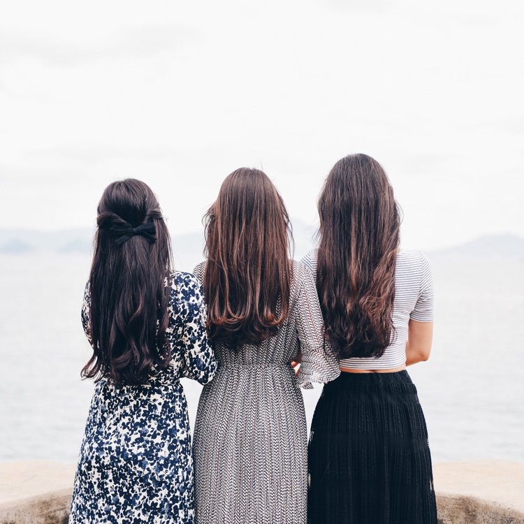 The silhouette of three women with locked arms