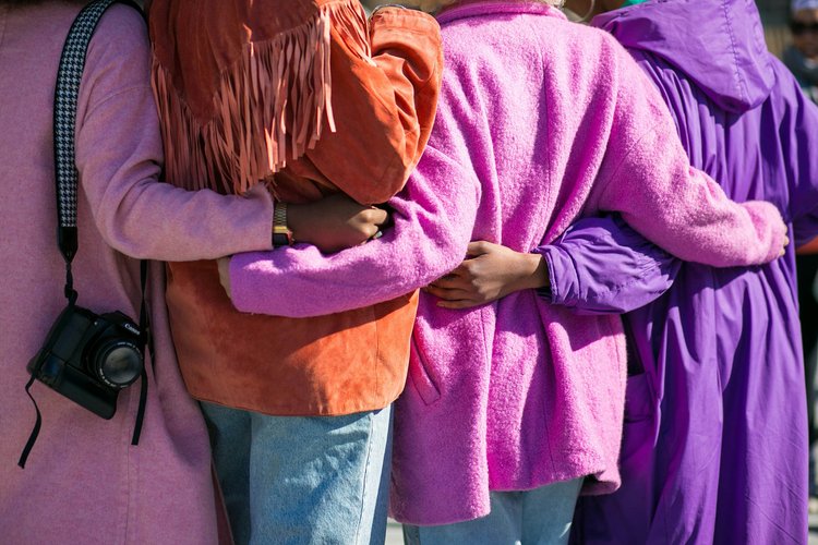 A group of women of color embracing each other 