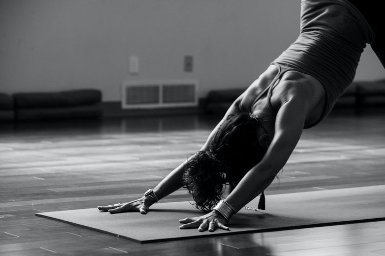 A black and white image of someone doing yoga