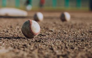 Baseballs in the dirt of a baseball field