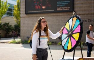 Someone playing a spinning wheel game while tabling at Seawolf Plaza