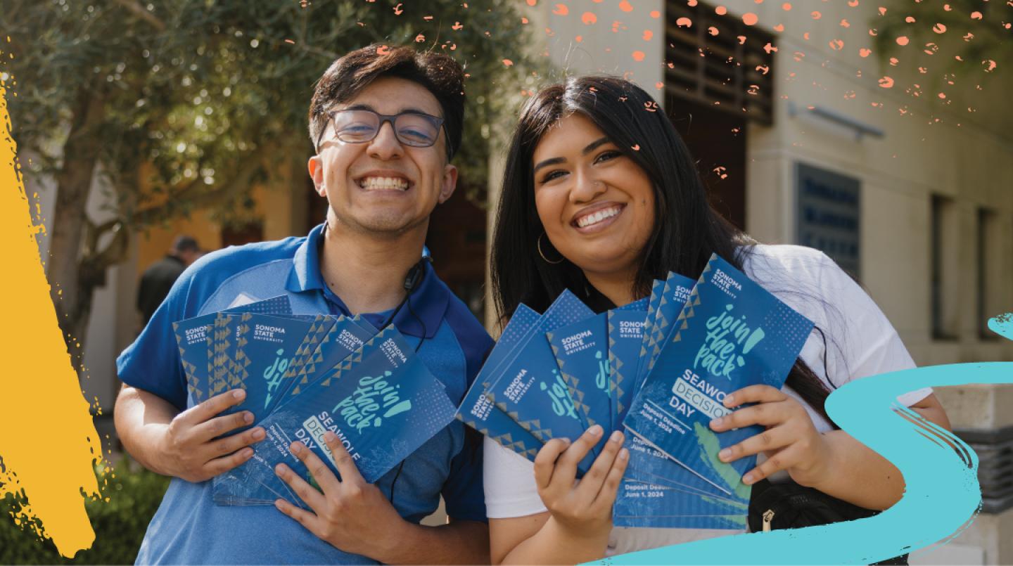 Two students holding Join the Pack Brochures