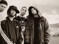 A black and white portrait of the hip hop group The Souls of Mischief standing together in an outdoor setting