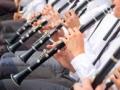 A row of people playing clarinets