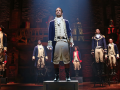 Actors in costume on stage performing Hamilton