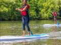 Two people smiling while paddleboarding 