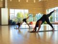 Two people doing a yoga pose inside the SSU gym