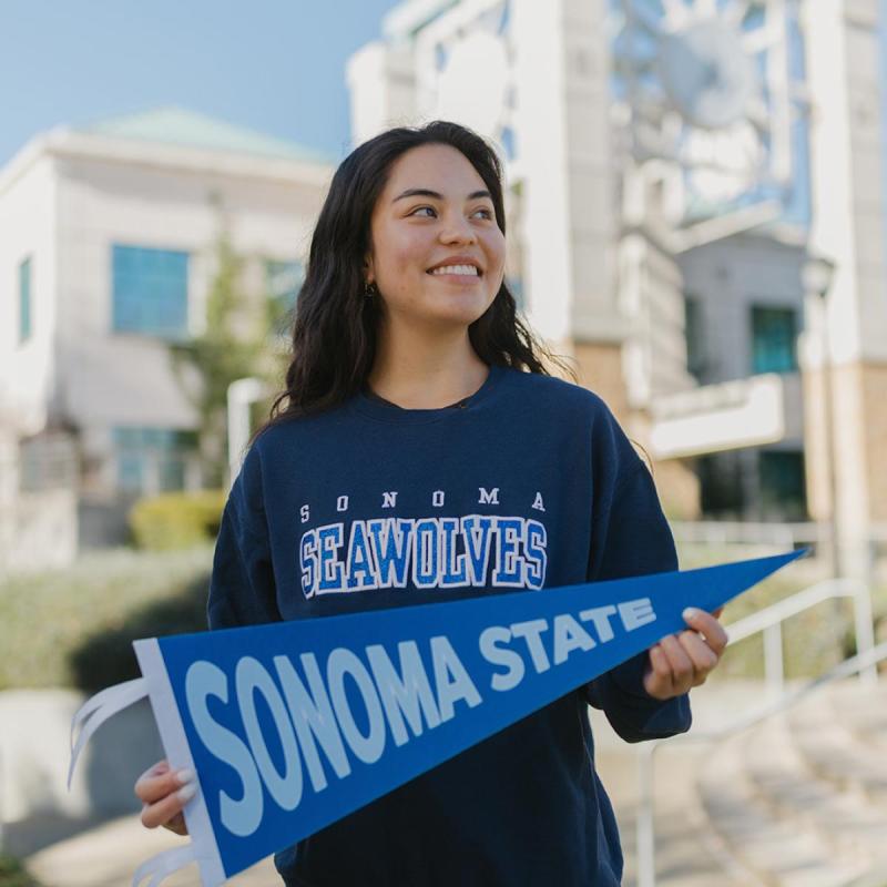 Student holding Sonoma State pennant