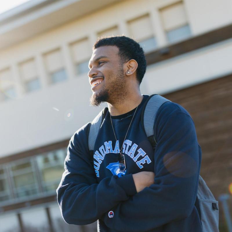 Student with arms crossed wearing a Sonoma State sweatshirt