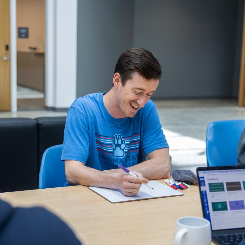 Student smiling while writing down notes