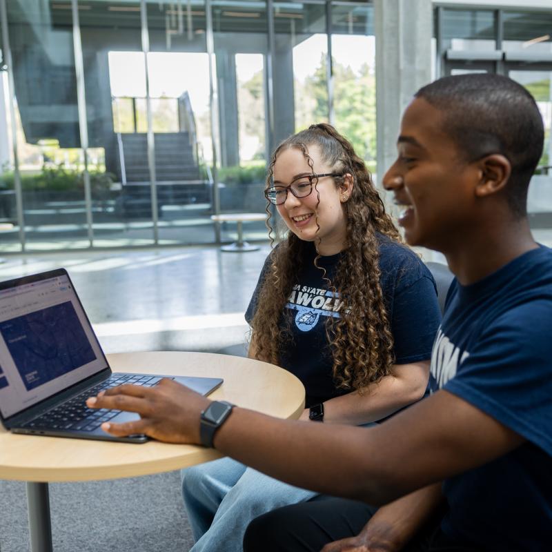 Student helping friend finding resources
