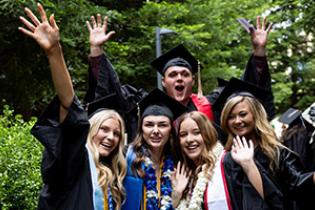 graduates wave at camera